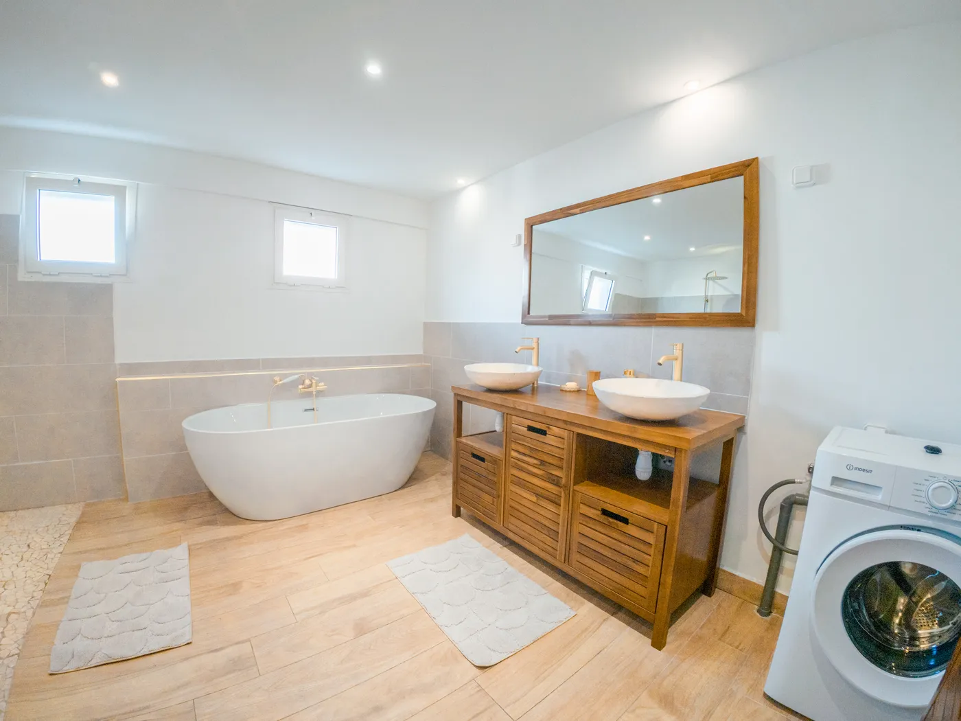 Grande salle de bain avec baignoire îlot et double vasque