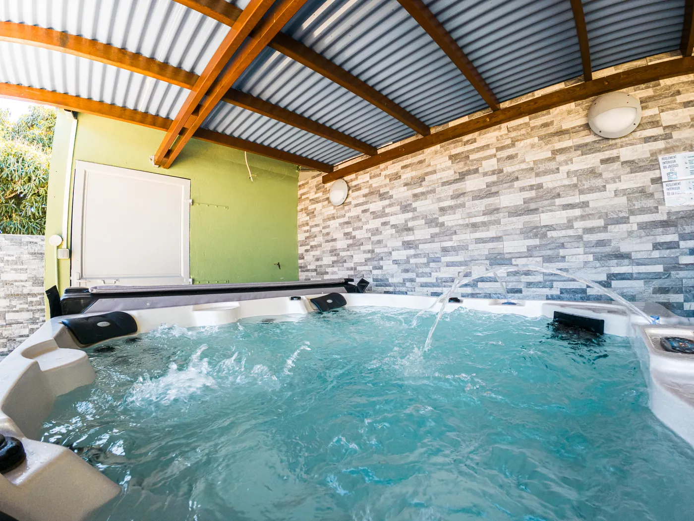Jacuzzi avec jets d'eau sous la pergola
